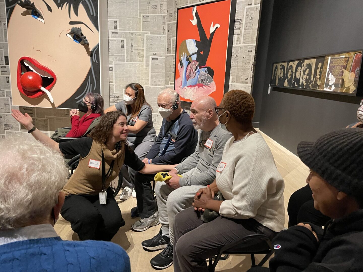 A group engaged in a lively discussion in an art gallery setting.