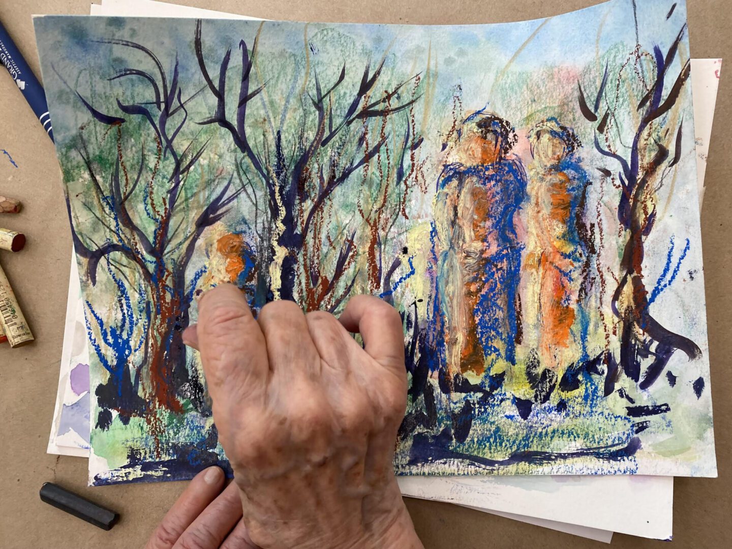 An artist paints a vibrant, abstract forest scene with tall, colorful figures.