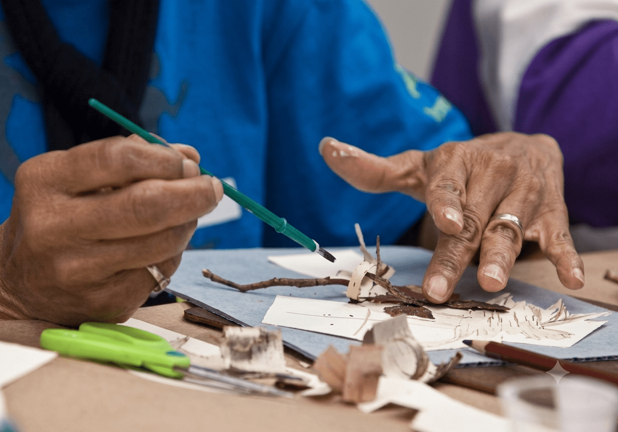 Hands crafting with paper and paintbrush.