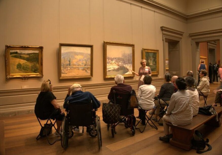 Museum guide discussing artwork with audience